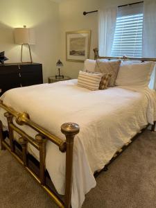 een groot bed met witte lakens en een raam bij The Terrace Room @ Galleria in Houston