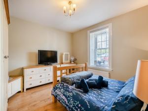 a bedroom with a bed and a flat screen tv at Curlew Cottage in Caister-on-Sea