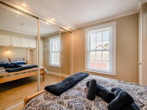 a bedroom with two beds and a mirror at Curlew Cottage in Caister-on-Sea
