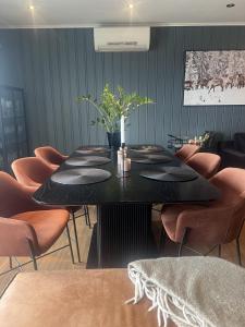 a dining room with a black table and orange chairs at All inclusive villa in Lillehammer
