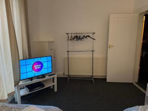 a living room with a tv and a table with a tv stand at 140 MAIN ST GROUND LEFT in Largs