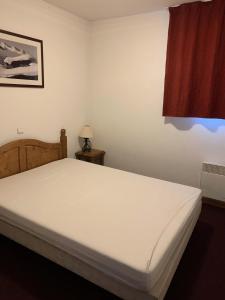 un lit blanc dans une chambre avec une fenêtre dans l'établissement Résidence Cristallines - 2 pièces 4 personnes MAE-4444, à Orcières