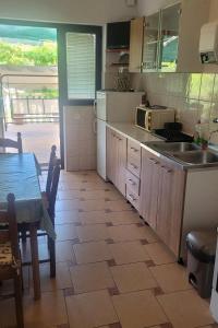 una cucina con tavolo e tavolo e una cucina con tavolo di Apartments with a parking space Sali, Dugi otok - 8136 a Sali (Sale)