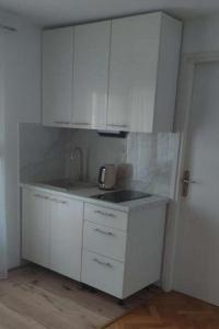een keuken met witte kasten en een wastafel bij Apartments with a parking space Slunj, Plitvice - 22111 in Slunj