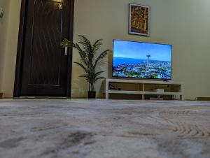 TV de pantalla plana en la sala de estar. en Comfort Bed Inn en Dubái