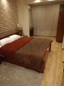 a large bed in a room with a brick wall at Louran Residence Hotel Apartments in Alexandria