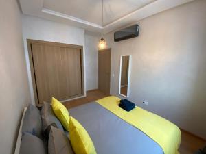 1 dormitorio con 1 cama grande con sábanas amarillas en Appartement près de Novotel face au parc, en Mohammedia