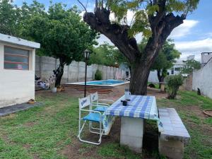 a picnic table and chairs in a yard with a tree at Chalet MAX in Bialet Massé