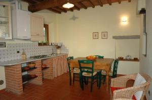 uma cozinha com mesa e cadeiras num quarto em Appartement in Figline Valdarno mit Terrasse, Grill und Garten em Figline Valdarno
