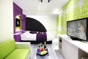 a hotel room with a bed and a tv and a couch at Hotel L'eclair (Adult Only) in Fukuyama