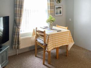 a table with a yellow and white checkered table cloth at Bramley Lodge Annex in Clenchwarton
