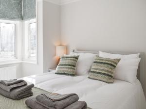 Un dormitorio blanco con una cama con toallas. en Beach View House, en Margate