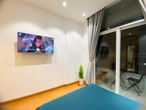 Alpha Homestay Marina Long Xuyên في Ấp Ðông An (1): غرفة معيشة مع تلفزيون بشاشة مسطحة على الحائط