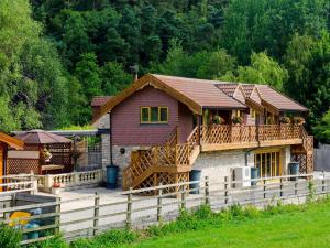 a house with a deck and a fence at Magnolia Lodge-uk46280 in Camerton