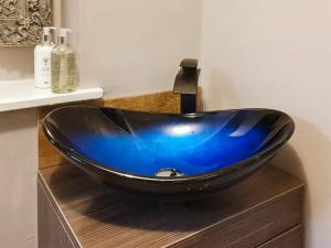 a blue sink sitting on top of a wooden counter in a bathroom at Hindscarth Apartment - Uk39610 in Davidstow