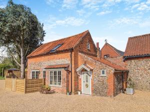 a brick building with a white door and a fence at Rose Cottage - Ukc4238 in Great Snoring