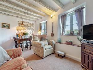 a living room with a chair and a television at Vine Cottage - Ukc4237 in Great Snoring