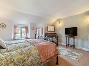 a bedroom with a bed and a flat screen tv at Vine Cottage - Ukc4237 in Great Snoring