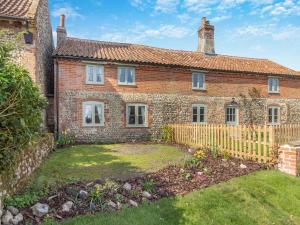 an old brick house with a wooden fence at Vine Cottage - Ukc4237 in Great Snoring