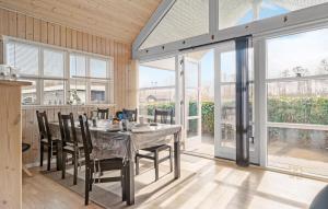 Un comedor con mesa y sillas y ventanas. en 3 Bedroom Gorgeous Home In Storvorde, en Storvorde