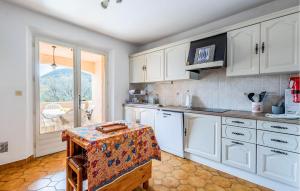 een keuken met witte kasten en een tafel bij Gorgeous Home In Les Adrets-de-lestre With Wifi in Les Adrets de l'Esterel