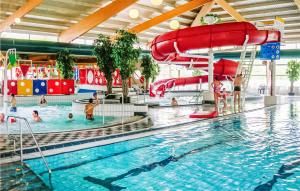 een zwembad met een glijbaan en mensen in het water bij Amazing Home In Vlagtwedde With Indoor Swimming Pool in Vlagtwedde