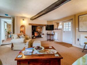 a living room with a table and a fireplace at Cherry Tree Cottage - Uk30237 in Great Snoring