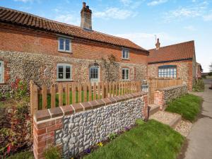 a brick house with a fence in front of it at Cherry Tree Cottage - Uk30237 in Great Snoring