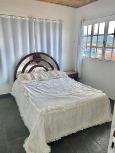 um quarto com uma cama grande e uma cabeceira em madeira em CASA EM GUARAPARI em Guarapari