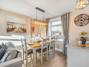 uma cozinha e sala de jantar com mesa e cadeiras em Snowdrop Cottage em Seahouses