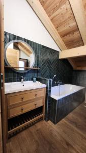 a bathroom with a sink and a tub and a mirror at Chalet Totoro - Chalets pour 14 Personnes 514 in Valloire