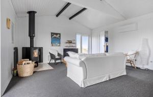 a living room with a white couch and a fireplace at Gorgeous Home In Bogense With Kitchen in Bogense