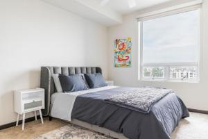 een slaapkamer met een groot bed en een raam bij Brand New 2BR Luxury Apartment WeHo in Los Angeles