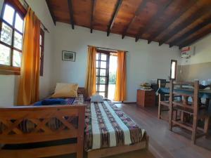 ein Schlafzimmer mit einem Bett, einem Schreibtisch und Fenstern in der Unterkunft Arena&Mar in San Clemente del Tuyú