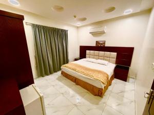 1 dormitorio con cama y cortinas verdes en مرفق ضيافة خاص - شقة عائلية, en Al Fayşalīyah 2 fotos más