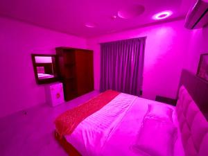 a pink bedroom with a bed and a mirror at مرفق ضيافة خاص - شقة عائلية in Al Fayşalīyah