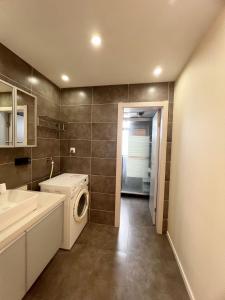 a bathroom with a washing machine and a sink at Shanghai Jing'an Temple Designer Boutique Large Four Rooms Apartment in Shanghai