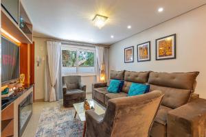 ein Wohnzimmer mit Sofa und Tisch in der Unterkunft Casa em condomínio até 8 p e 2 vagas in Canela