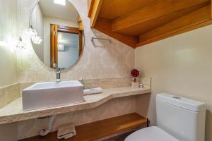 ein Badezimmer mit Waschbecken, Spiegel und Toilette in der Unterkunft Casa em condomínio até 8 p e 2 vagas in Canela + 27 Fotos