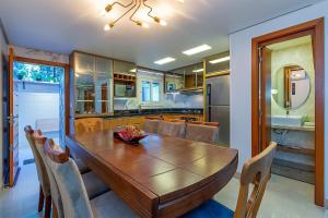 eine Küche mit einem Holztisch und Stühlen in der Unterkunft Casa em condomínio até 8 p e 2 vagas in Canela