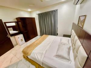 a bedroom with a large bed and a window at مرفق ضيافة خاص - شقة عائلية in Al Fayşalīyah