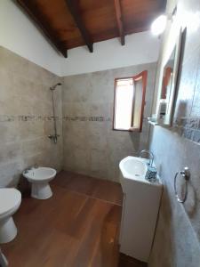 ein Badezimmer mit zwei Waschbecken und einer Toilette und einem Fenster in der Unterkunft Arena&Mar in San Clemente del Tuyú