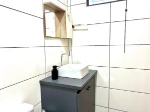 a bathroom with a sink and a mirror at CHARMOSO E BEM LOCALIZADO in Maracaju