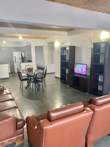 uma sala de estar com uma mesa e cadeiras e uma televisão em CASA EM GUARAPARI em Guarapari