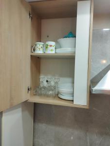 un placard avec des assiettes, des bols et de la vaisselle dans l'établissement Maison tnazefti, à Djerba