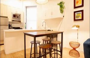 a kitchen with a table and stools in a room at Medina’s estate in Bronx