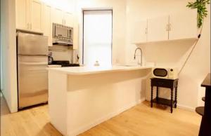 uma cozinha branca com um lavatório e um frigorífico em Medina’s estate em Bronx