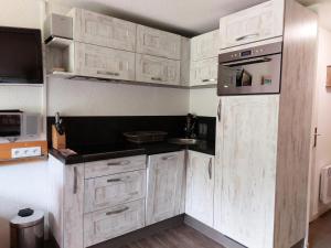 uma cozinha com armários brancos e um micro-ondas em Résidence Aiguille Grive Bat Iii - 3 Pièces pour 6 Personnes 441 em Arc 1800