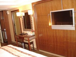 Habitación de hotel con cama, escritorio y TV. en Attic Hotel, en Taipéi