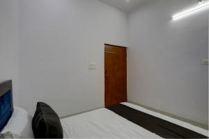 pokój z drzwiami i łóżkiem w pokoju w obiekcie OYO HOTEL KAVYA RESIDENCY w mieście Aligarh